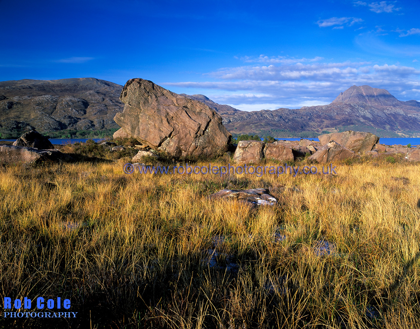 A massive erratic boulder lies on the banks of Loch Maree